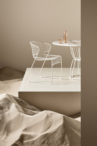 ND chair and table set against a neutral wall with sandstone textures.