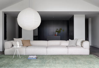 Living room with white sofa and paper lantern.