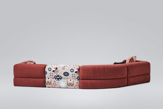 Red sectional sofa with patterned cushion.