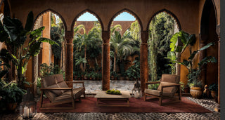 Outdoor seating area with arched doorways and plants.