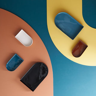 Arc-shaped trays in various colors on a geometric background