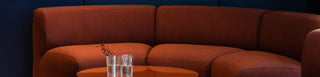 High-resolution banner image featuring a stylish orange sofa and table.