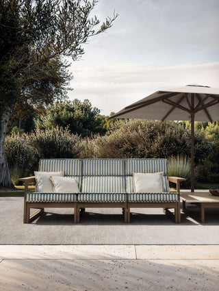 Tan Guor Residence I outdoor patio with striped sofa and umbrella.