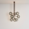 Modern chandelier with multiple glass shades on a white wall