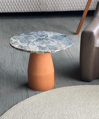 Small round table with marble top and terracotta base in a room setting