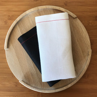 White and black cloth napkins on a wooden tray
