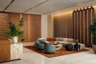 Modern lobby with seating, plants, and wood paneling.