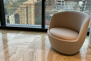 Shelly armchair with ribbed upholstery in an office setting overlooking the Sydney skyline