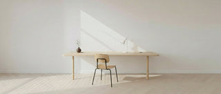 Minimalist desk setup with a chair in a bright room