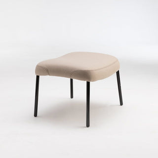 Beige upholstered stool with black legs.