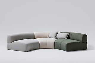 Curved modular sofa with two pillows.