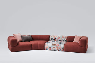 Red sectional sofa with patterned cushions.