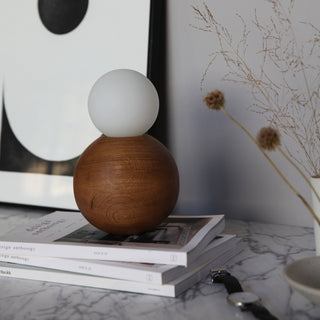 BrightBeads sphere table lamp off, wood base, in situ on books