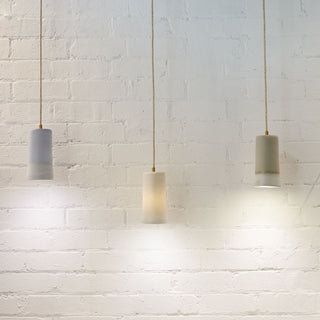 Dusked pendant lights against white brick