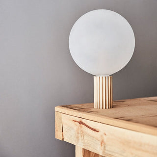 Table lamp with globe shade on wooden table